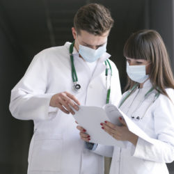 doctors-in-masks-with-documents_23-2147763860